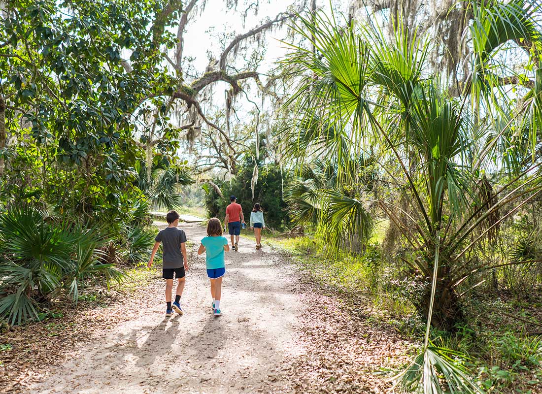 About Our Agency - Family Hiking Outdoors on a Path in Florida